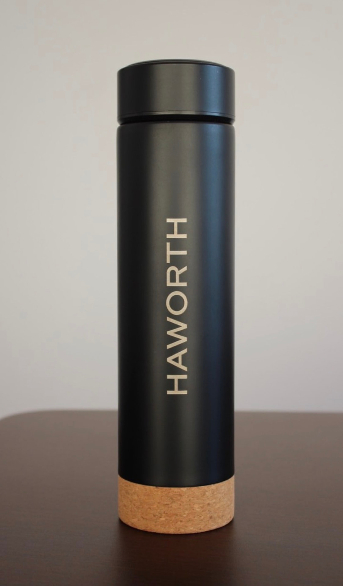 Black thermal bottle with cork base engraved with the Haworth logo