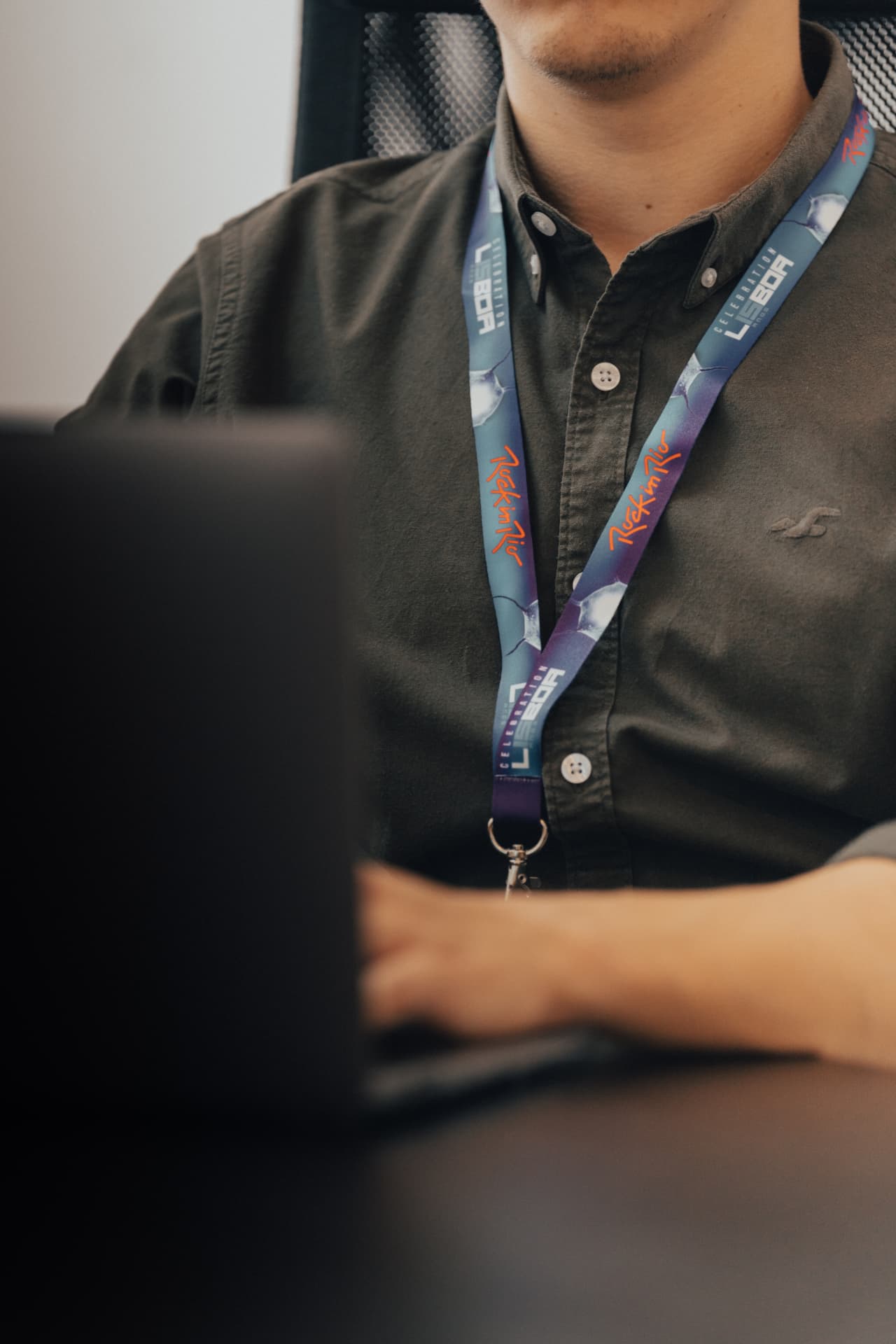 Rock in Rio Lisboa full-colour printed lanyard worn at an office desk