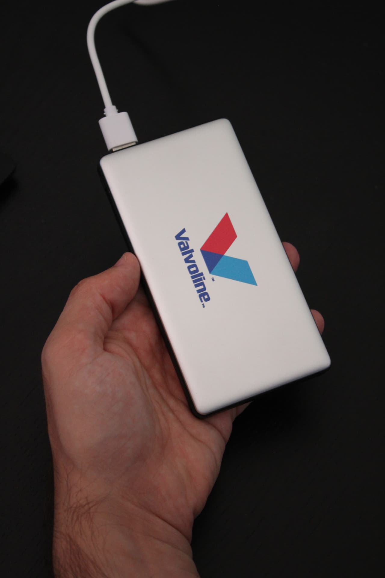 Slim white power bank printed with the Valvoline logo